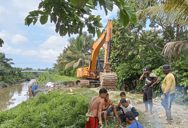 Warga Desa Teturi Kecamatan Sabbang Selatan bergotong royong perbaiki tanggul rusak dengan bantuan alat berat dari Pemerintah Desa, Selasa, 21 Mei 2024.